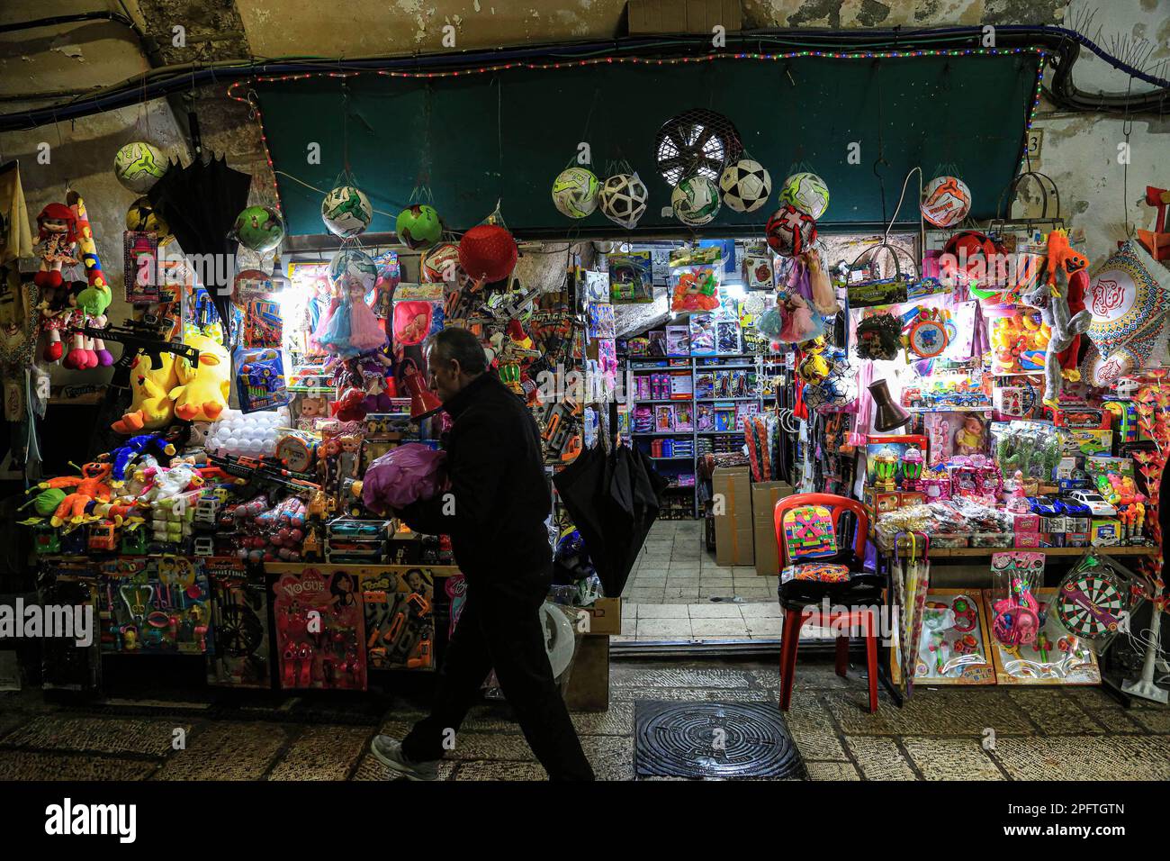 15 mars 2023, Jérusalem-est, Israël: Un homme marche devant un magasin de jouets pour enfants, avant le mois de jeûne du Ramadan, à Jérusalem. Le mois du Ramadan est considéré comme distinct parmi les musulmans et a un statut spécial par rapport au reste des mois de l'année Hijri. C'est le mois du jeûne, qui est considéré comme l'un des piliers de l'Islam, pendant lequel les musulmans s'abstiennent (sauf ceux qui ont une excuse valable) de nourriture et de boisson, ainsi que d'un groupe d'interdictions qui annulent le jeûne de l'aube. Et jusqu'au coucher du soleil. (Credit image: © Saeed QAQ/SOPA Images via ZUMA Press Wire) ÉDITORIAL Banque D'Images