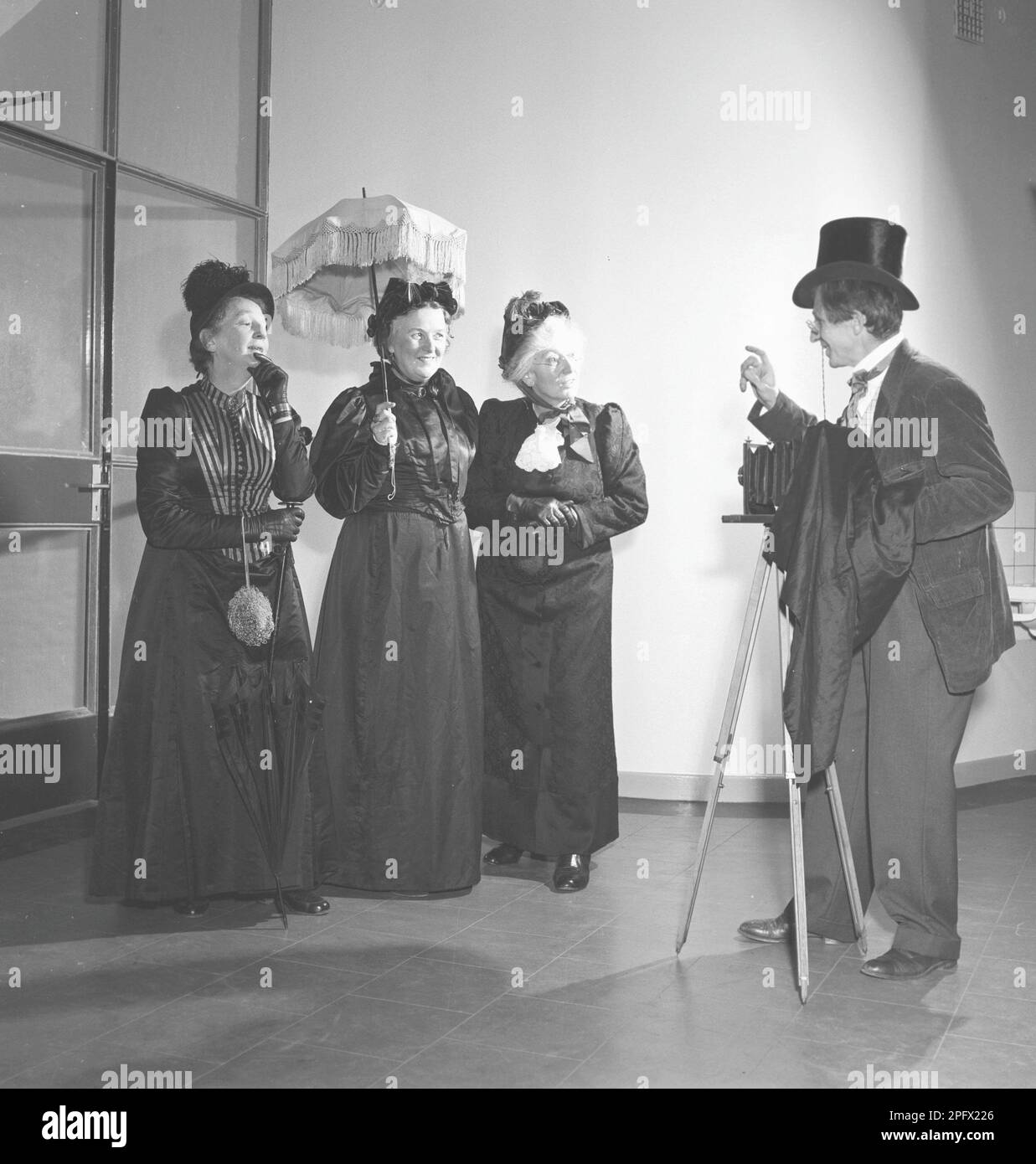 Trois femmes âgées vêtues de robes du début du siècle posent devant un photographe avec un appareil photo. Suède octobre 1953. Réf. SSMSAX000194L Banque D'Images