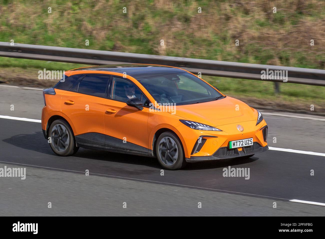 2022 (72) Orange MG 4 TROPHY électrique, à hayon entièrement électrique, EV long Range 64kWh 5dr voiture auto circulant sur l'autoroute M6, Royaume-Uni Banque D'Images