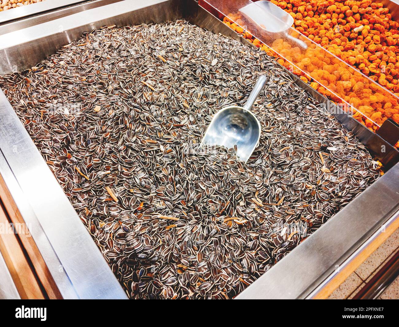 Boîte de graines de tournesol. Une pelle spéciale pour arroquer les gruaux en paquets. Le présentoir dans le magasin. Banque D'Images