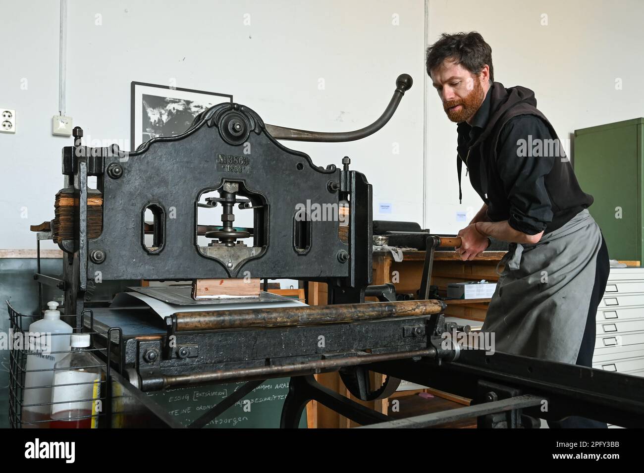 19 mars 2023, Saxe-Anhalt, Halle (Saale): Ilko Köstler imprime des lithographies avec une machine de 1895. Pour la Journée de l'imprimerie, Künstlerhaus 188 a invité les visiteurs à des ateliers, des estampes, des visites guidées et une exposition sur le thème de l'impression. Photo: Heiko Rebsch/dpa Banque D'Images