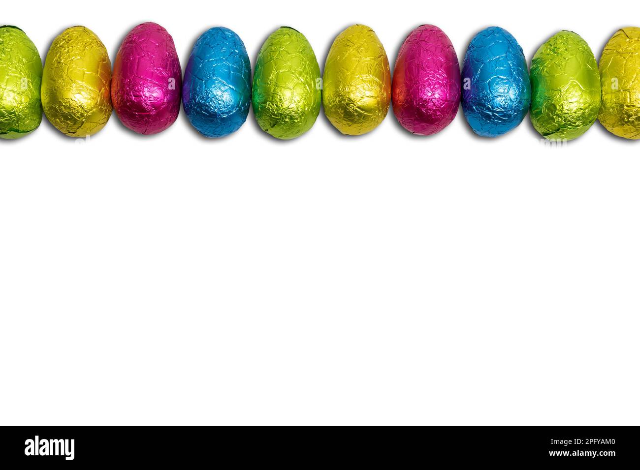 Œufs de Pâques enrobés de chocolat dans une rangée isolée sur blanc. Banque D'Images