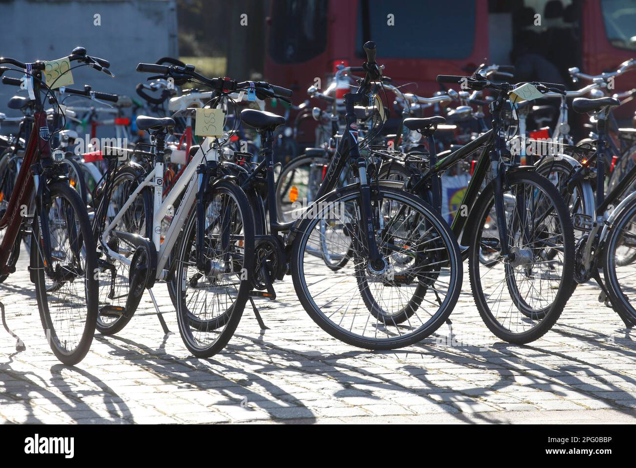 Parking vélos rétroéclairé avec étiquettes de prix sur l'asphalte sur un marché de vélos, Allemagne Banque D'Images