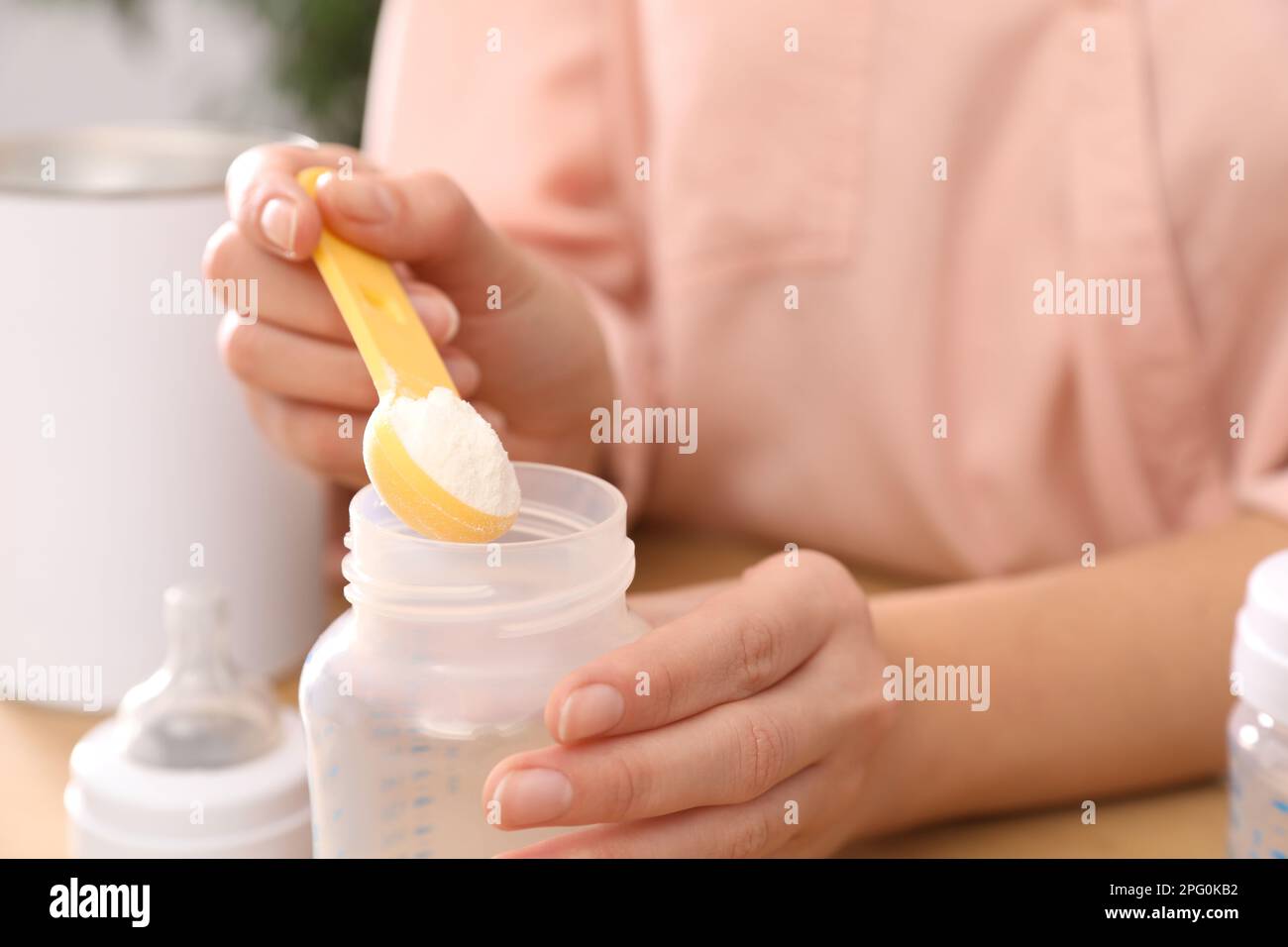 Femme préparant des préparations pour nourrissons à la table, en gros plan. Lait pour bébé Banque D'Images