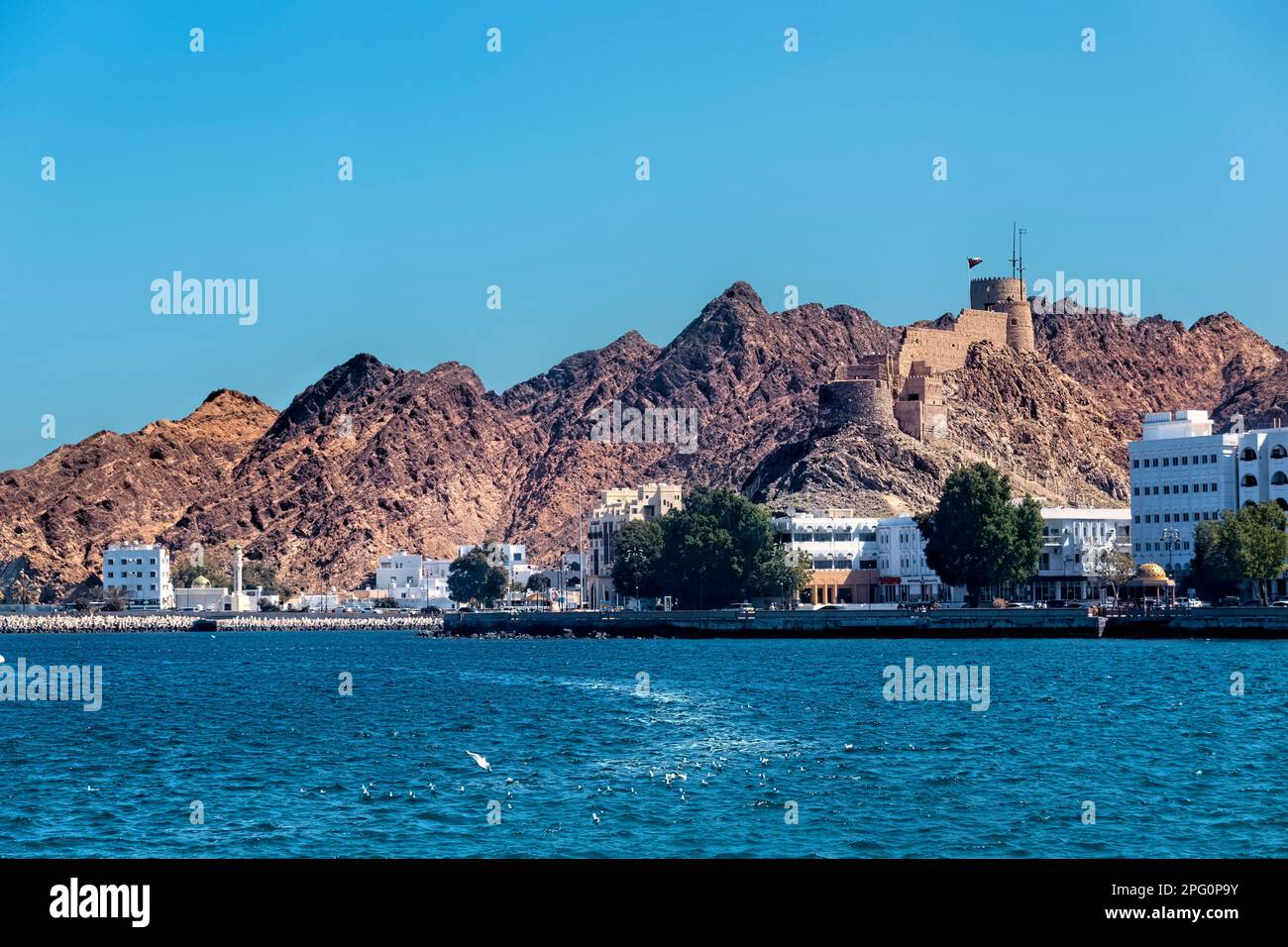 Vue sur l'ancien fort/tour d'observation et la corniche depuis le port de Mutrah, Muscat, Oman Banque D'Images