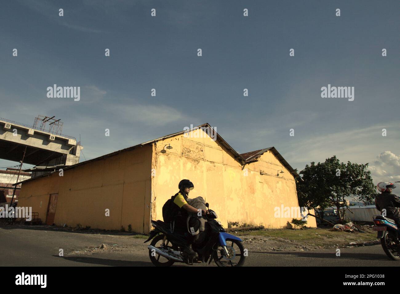 Les automobilistes sont photographiés dans un arrière-plan d'un entrepôt, dans la zone côtière de Manado, au nord de Sulawesi, en Indonésie. Banque D'Images