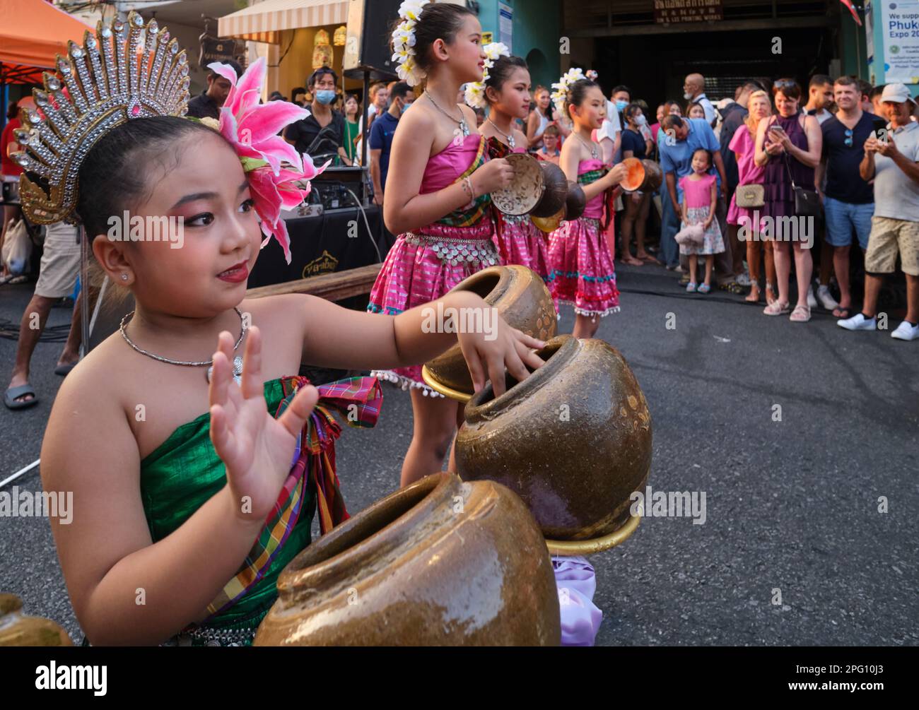 Une fille d'école thaïlandaise en costume traditionnel utilisant des navires comme batterie lors d'un événement culturel au marché de la rue de marche du dimanche, Phuket ville, Phuket, Thaïlande Banque D'Images