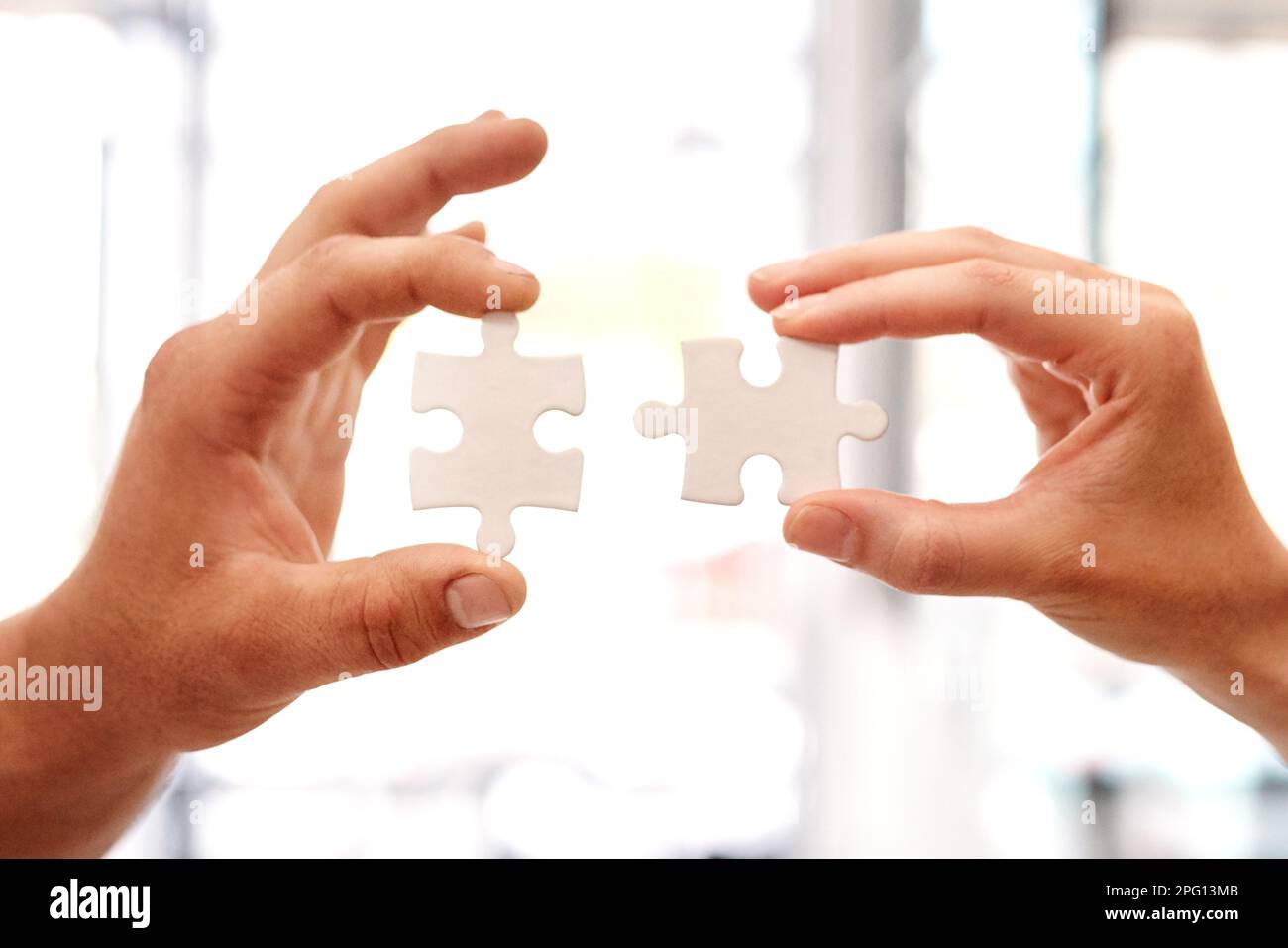 Mettre les morceaux de leur grand plan ensemble. Gros plan de deux hommes d'affaires non reconnaissables qui ont rassemblé des pièces de puzzle. Banque D'Images