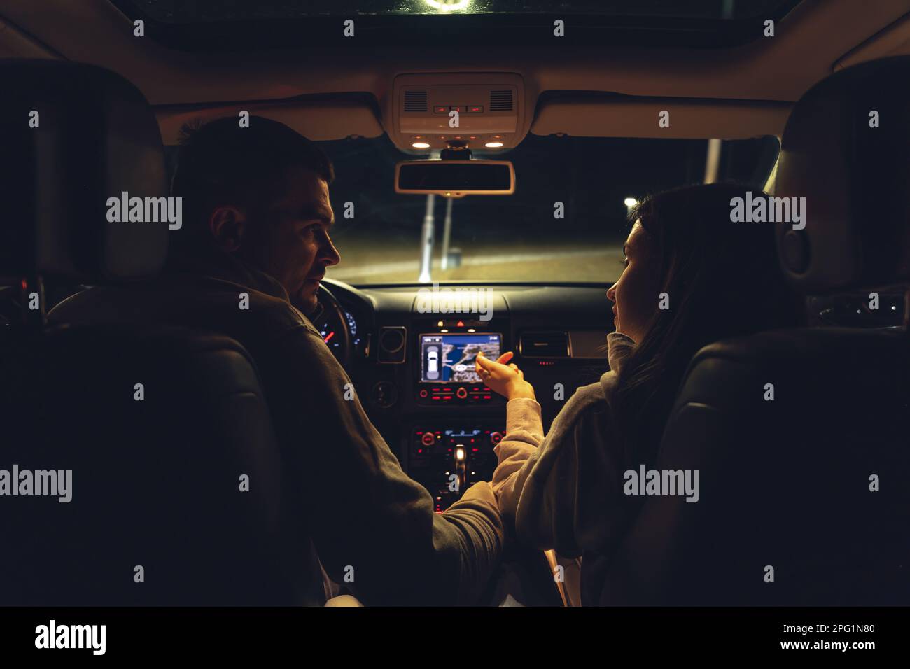 Homme et femme dans une voiture la nuit, vue de la voiture. Banque D'Images