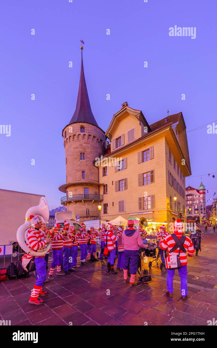Lucerne, Suisse - 20 février 2023: Groupe de musiciens en costumes et en foule, au lever du soleil, partie du Carnaval de Fasnacht, à Lucerne (Lucerne), SWI Banque D'Images