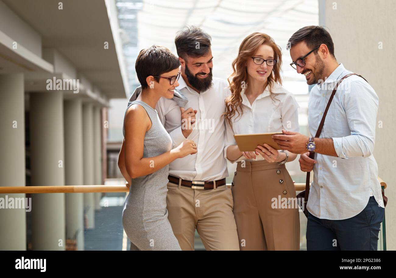 Des gens d'affaires heureux, des collègues dans un bureau moderne travaillant ensemble et utilisant une tablette Banque D'Images