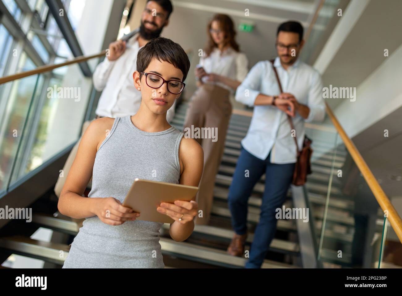 Des gens d'affaires heureux, des collègues dans un bureau moderne travaillant ensemble et utilisant une tablette Banque D'Images