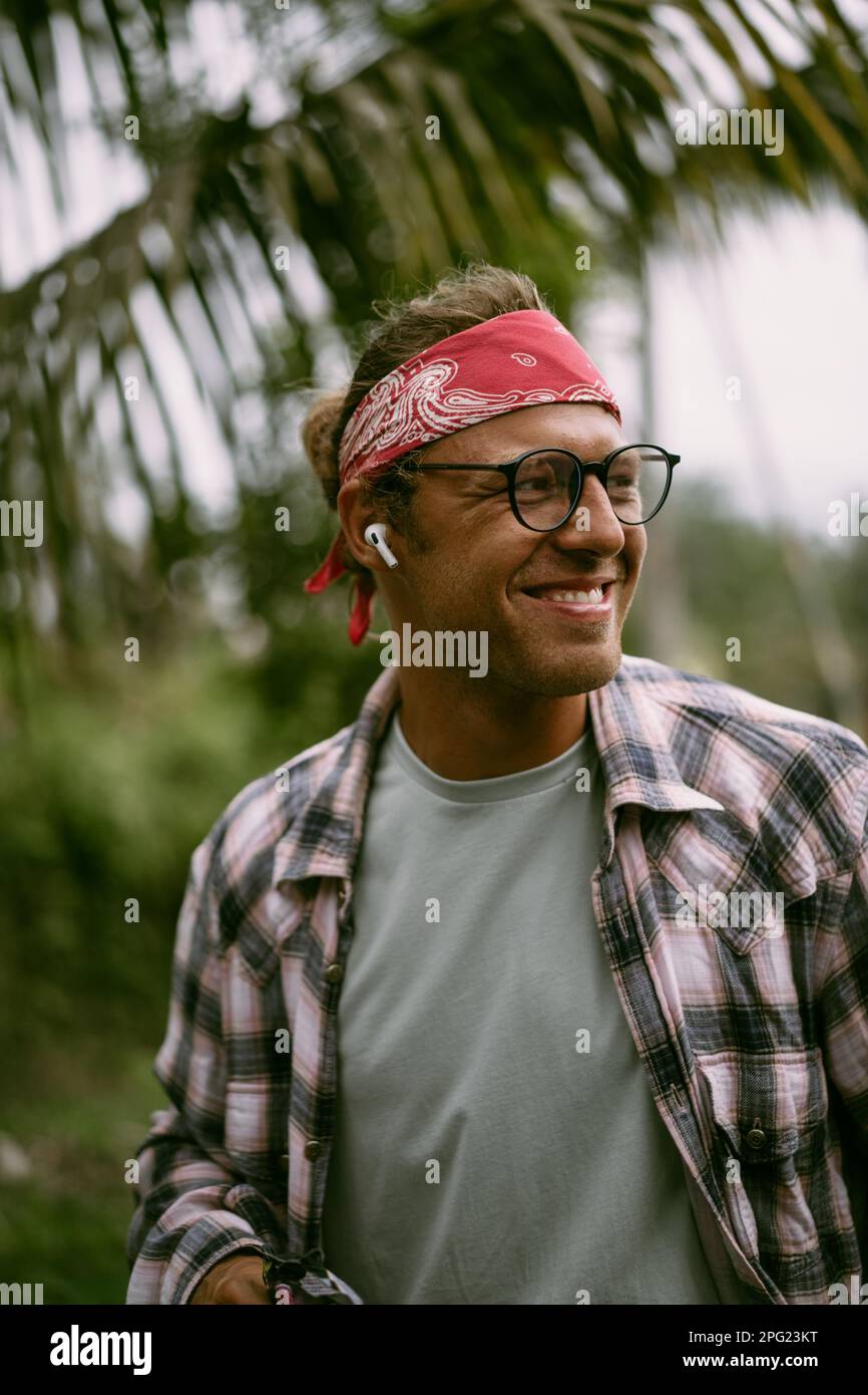 Jeune homme hippie élégant en bandana rouge et en verres. Vie sur l'île  Photo Stock - Alamy