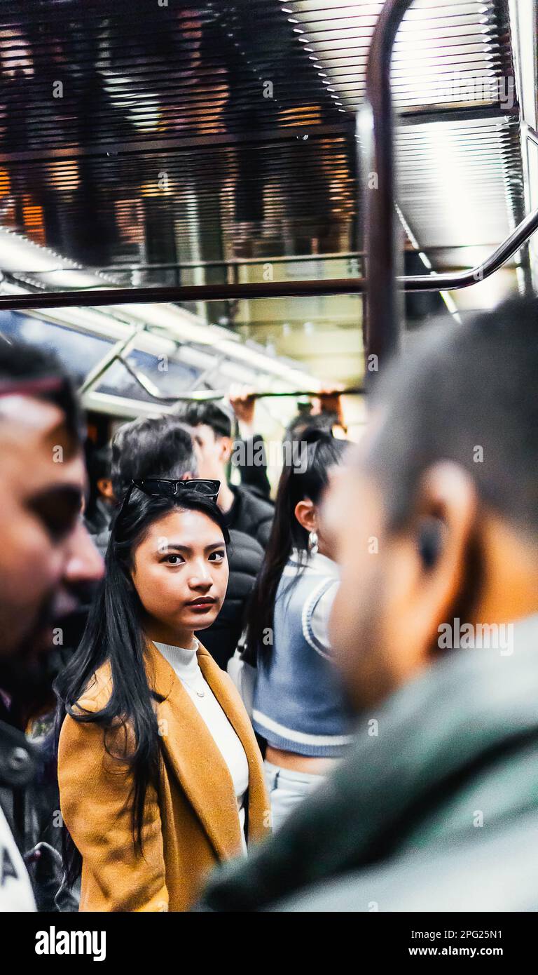 fille asiatique dans le métro entouré de gens Banque D'Images