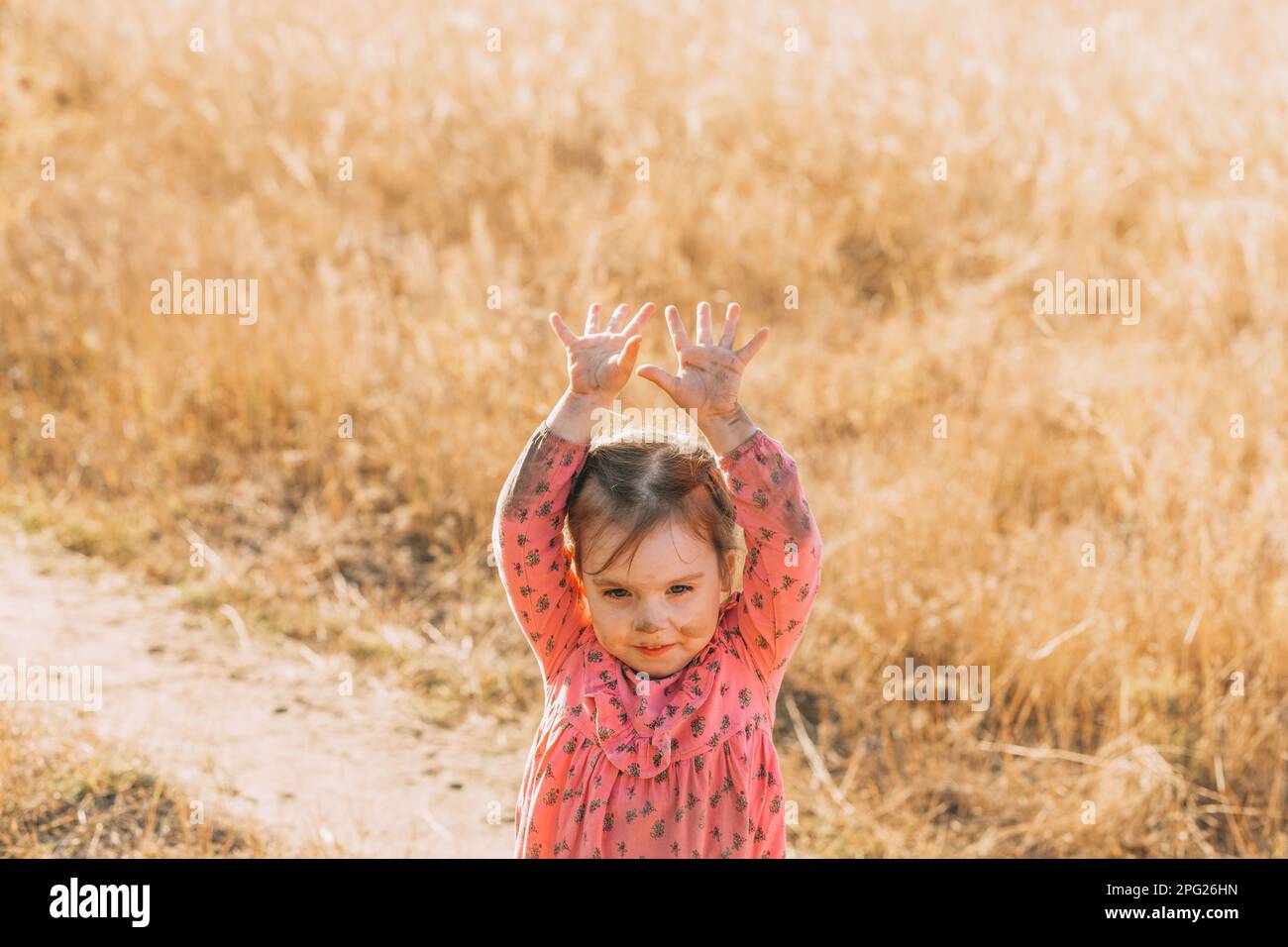 Petite fille avec un visage sale et des vêtements sales dans la nature avec sa mère. Enfants jouant dehors avec des mains sales. Banque D'Images