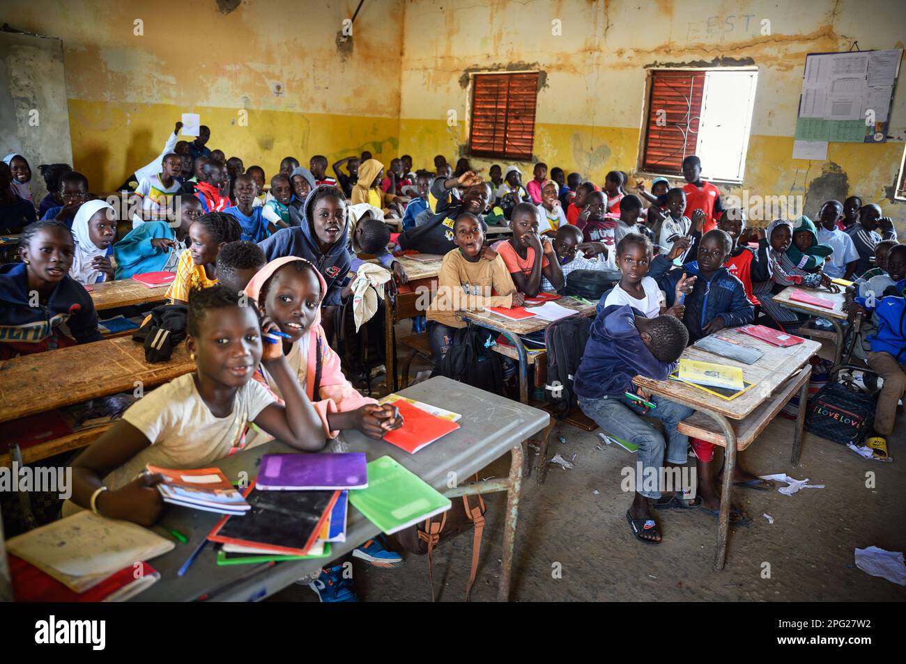 Des enfants africains assis à leur bureau dans une salle de classe dans ...