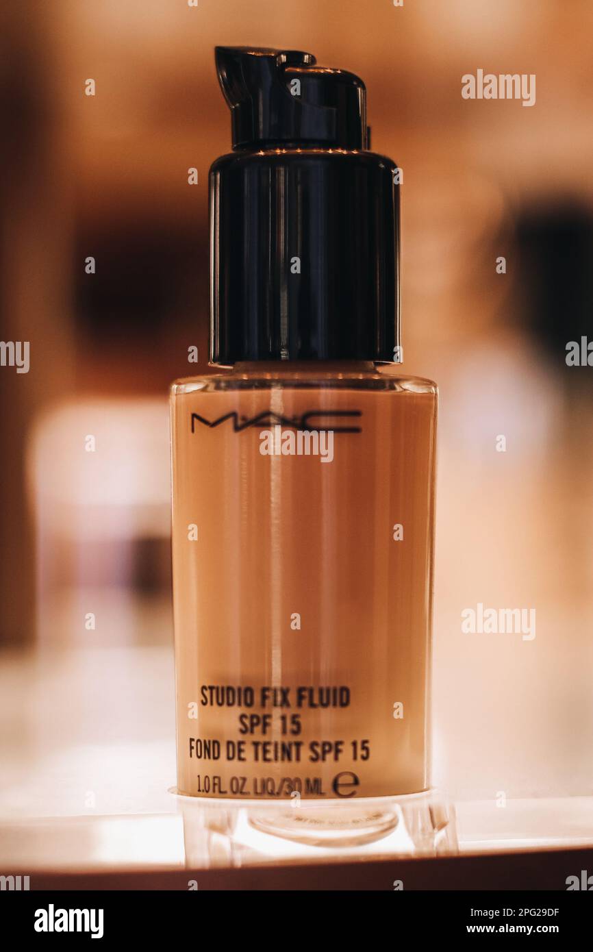 Tube en verre de la fondation Mac beige sur un support dans un magasin. Le concept de cosmétiques décoratifs pour le visage. Verticale Banque D'Images