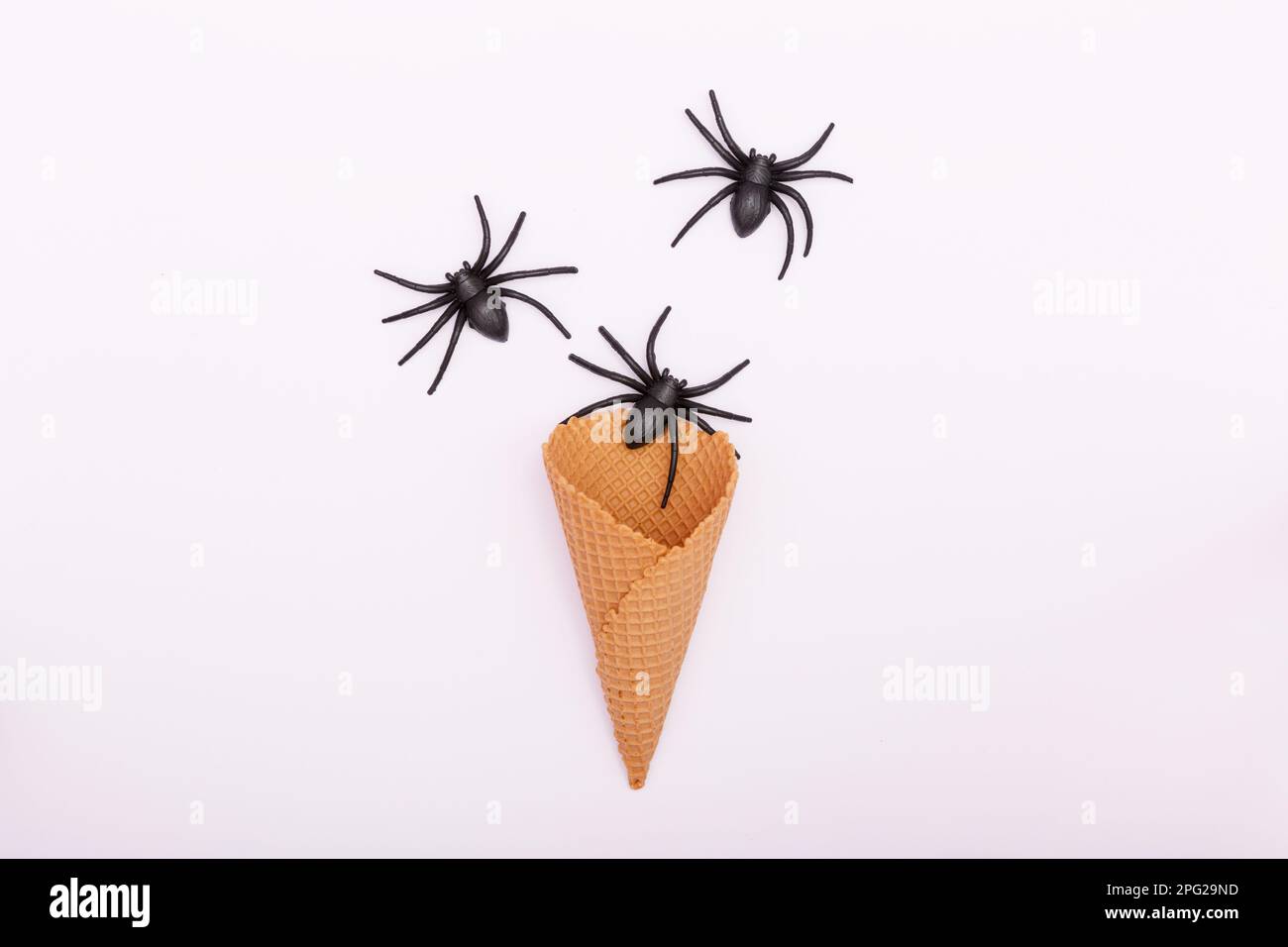 Concept Halloween. Araignées noires et un cône de crème glacée sur fond blanc. Vacances d'automne traditionnelles. pose à plat, espace de copie, minimalisme. Quali élevé Banque D'Images