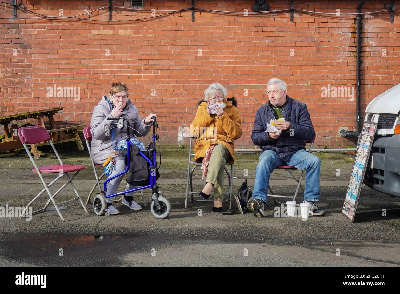 Trois personnes font une pause à la vente de bottes de voiture Ayr, Ayrshire, Écosse, Royaume-Uni Banque D'Images