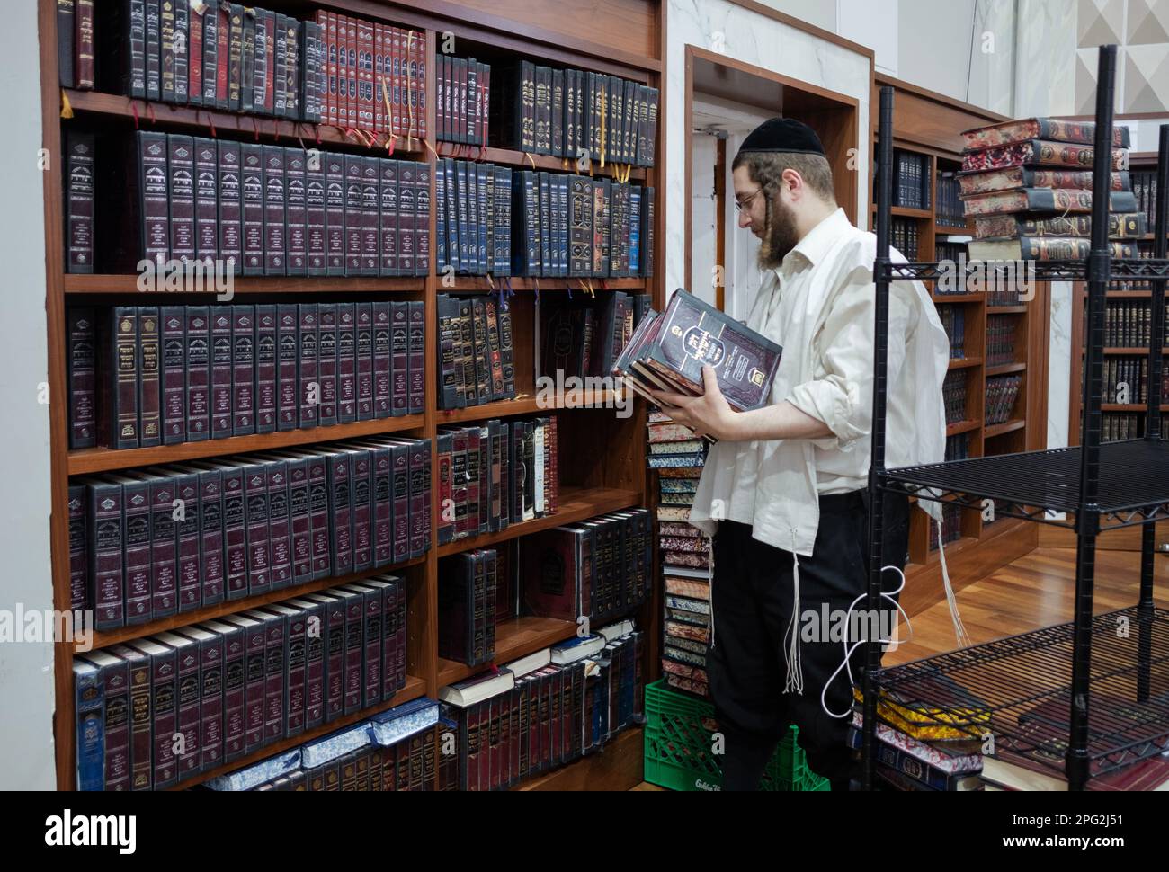 Un sexton dans une synagogue supprime des volumes d'Exode et ajoute des volumes de Lévitique afin que les fidèles puissent suivre les lectures de Torah. À New York. Banque D'Images