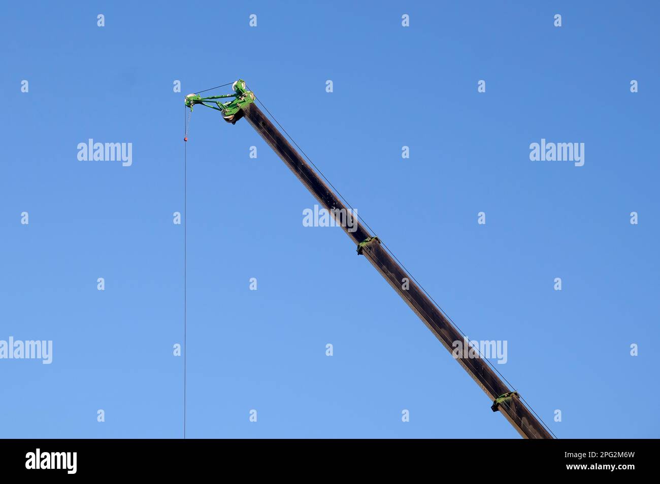 Manipulateur de grue à flèche longue haut dans le ciel bleu sans nuages Banque D'Images