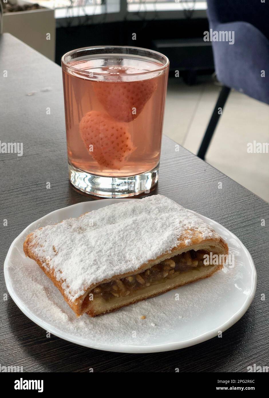 Strudel aux pommes avec sucre en poudre et compote de fraises dans un café Banque D'Images
