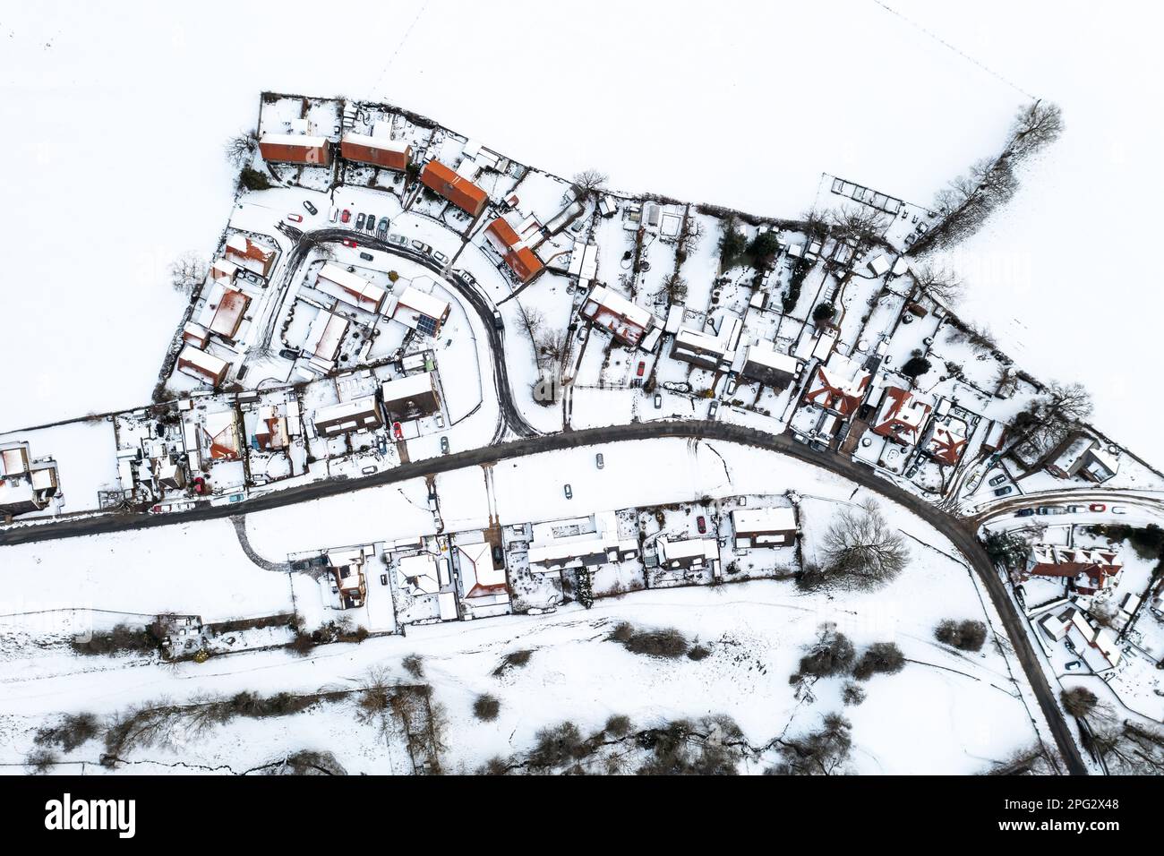Vue aérienne de style carte directement au-dessus d'un village de campagne avec des maisons couvertes de neige pendant la crise énergétique du Royaume-Uni avec perte de chaleur à travers les toits Banque D'Images