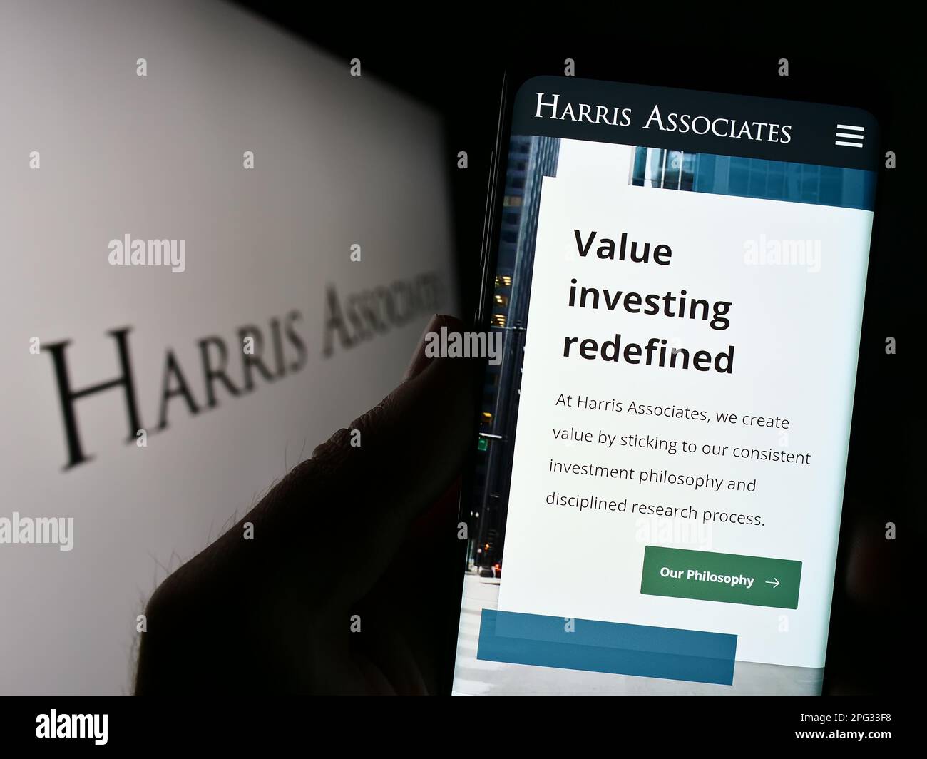 Personne tenant un téléphone portable avec le site Web de la société d'investissement américaine Harris Associates L.P. à l'écran avec logo. Concentrez-vous sur le centre de l'écran du téléphone. Banque D'Images