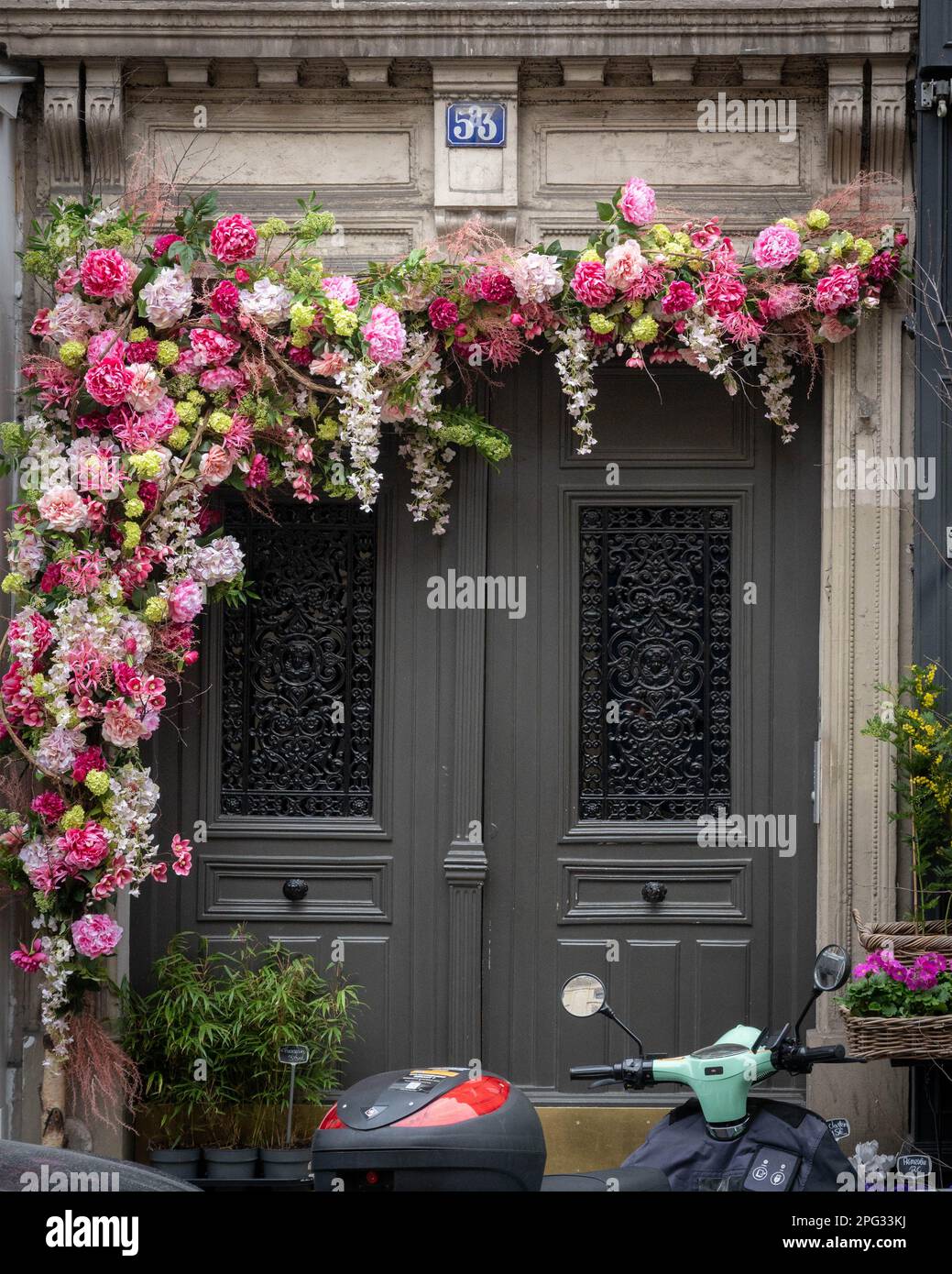 Belles fleurs autour de la porte de l'immeuble d'appartements à Paris Banque D'Images