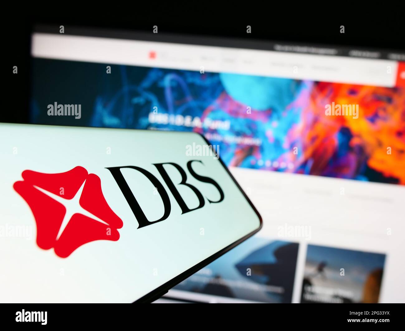 Téléphone portable avec logo de la société financière Singapourienne DBS Bank Limited à l'écran devant le site Web. Mise au point au centre-gauche de l'écran du téléphone. Banque D'Images