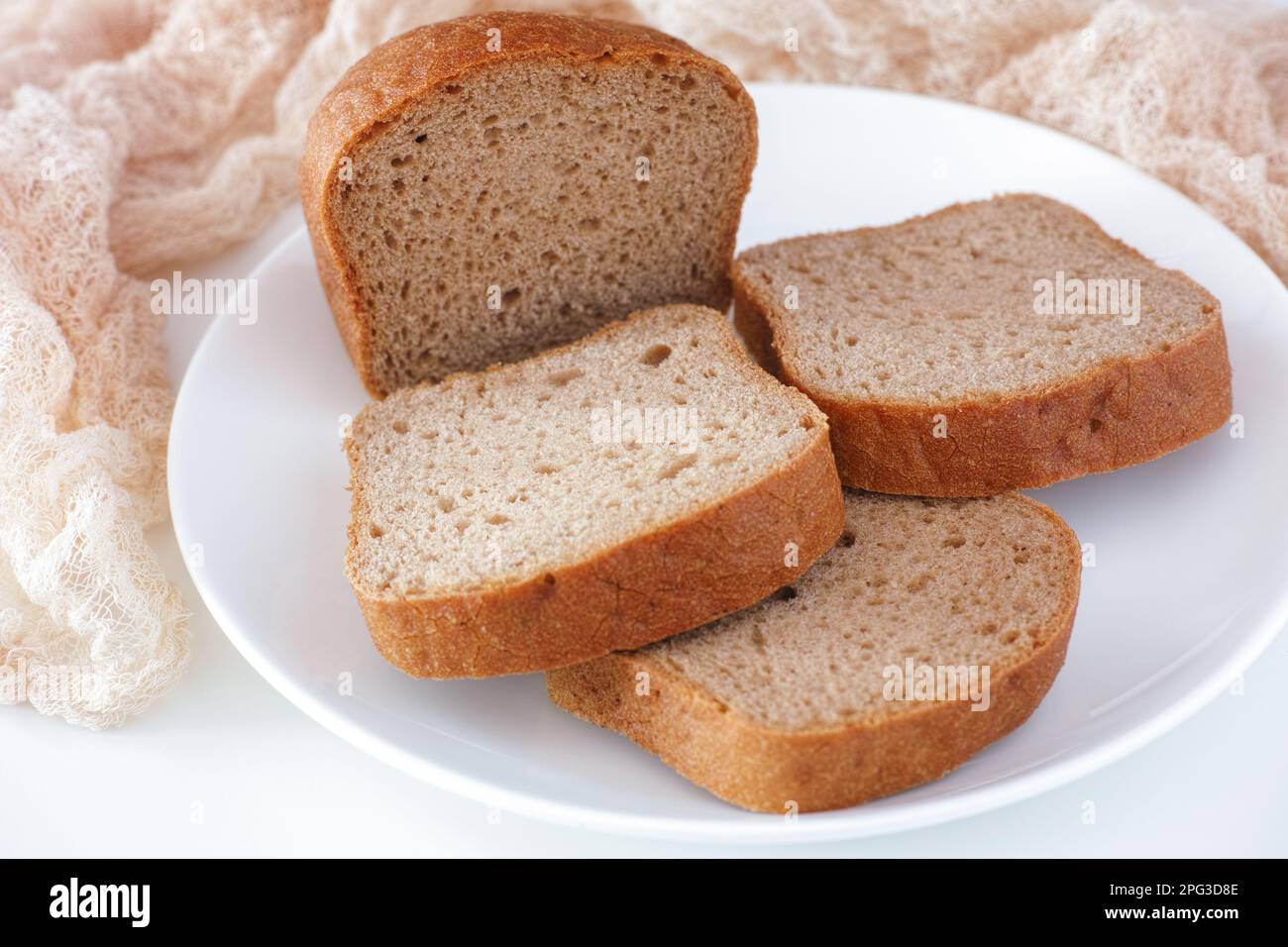 Tranches de pain sans gluten sur une assiette blanche. Gros plan. Banque D'Images