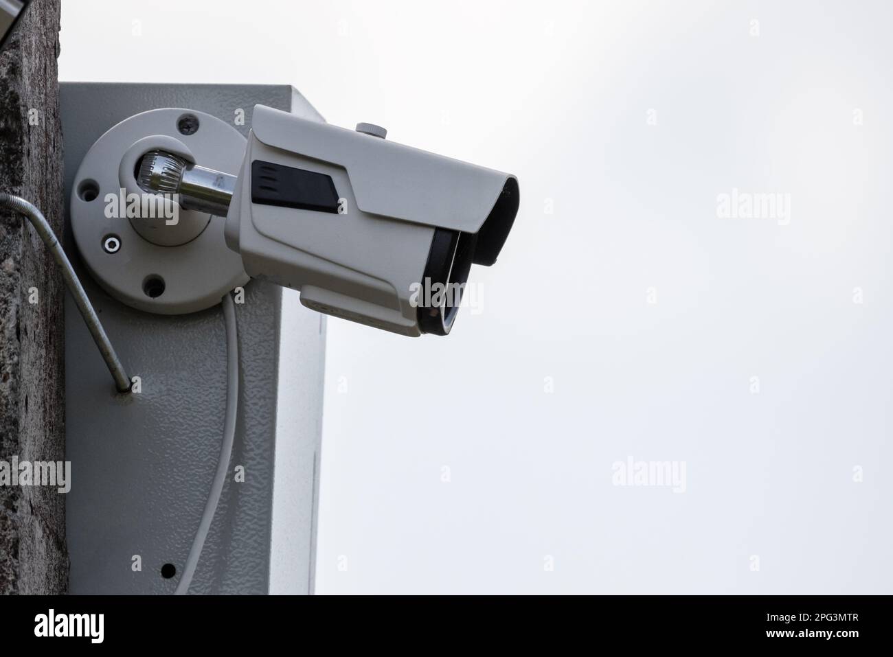 L'observation CCTV est en cours. La caméra de télévision en circuit fermé est montée sur un poteau de rue en béton sous un ciel lumineux Banque D'Images