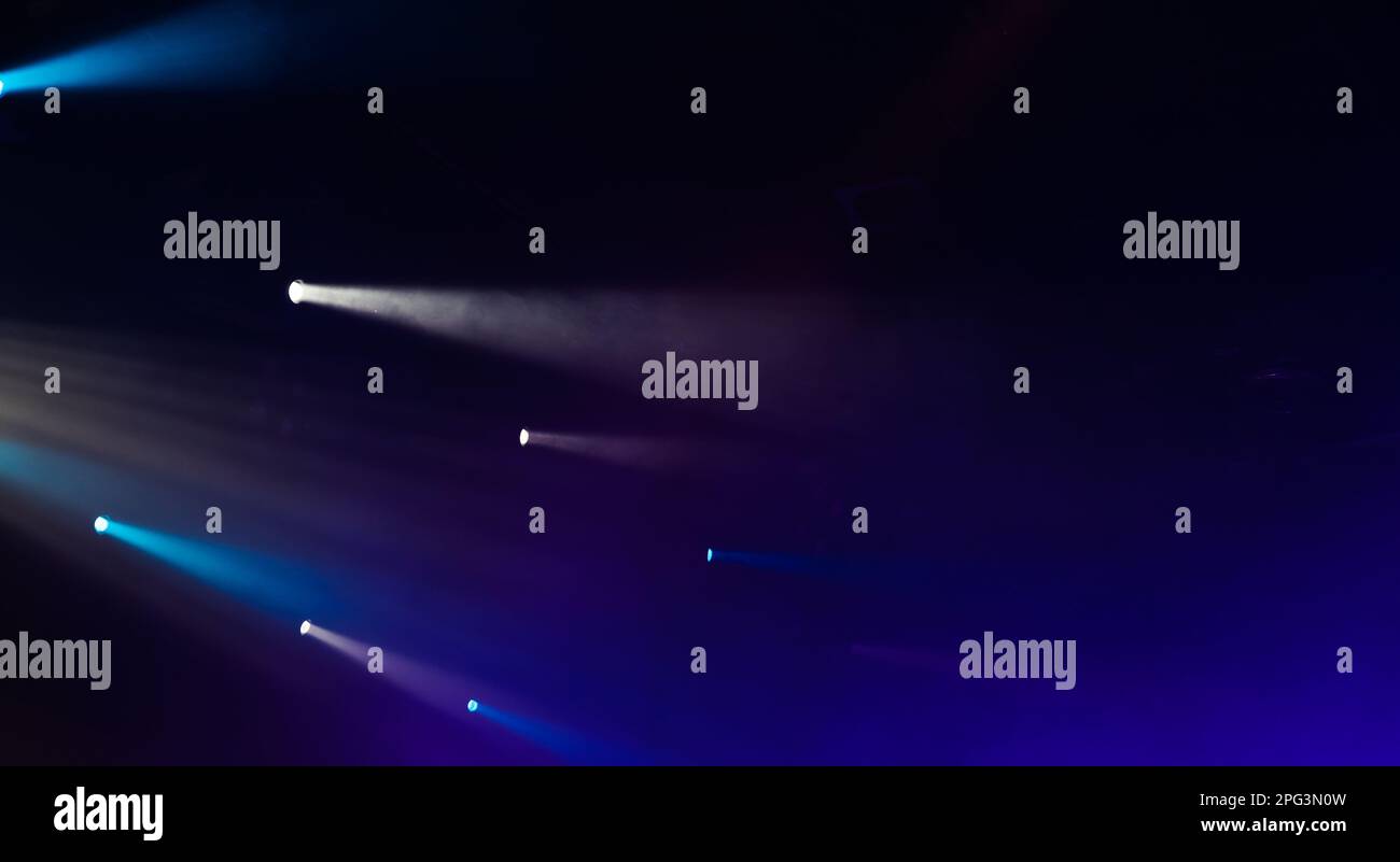 Faisceaux de spots pittoresques en fumée sur fond sombre, éclairage moderne Banque D'Images