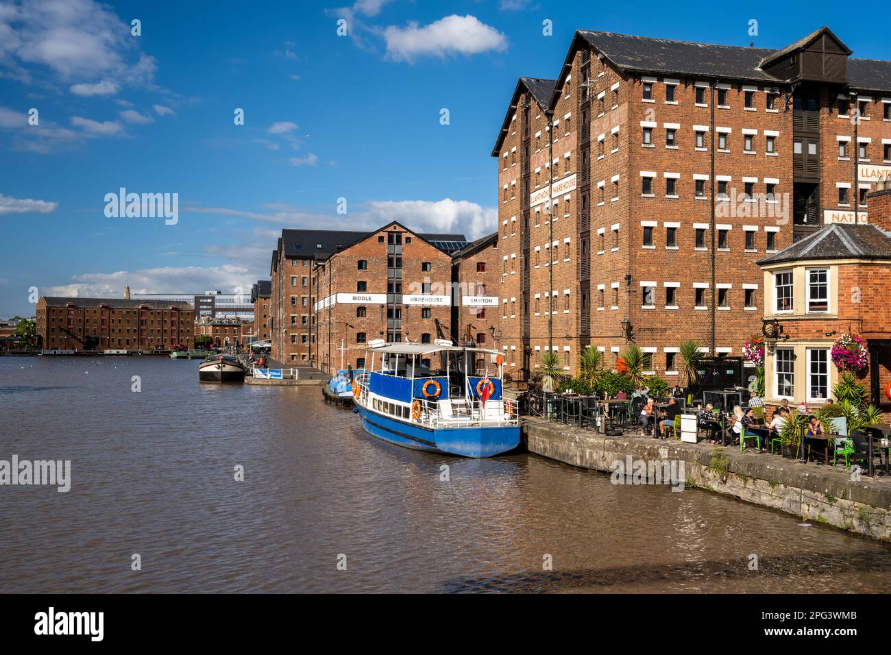 Les gens boivent dans un pub sur les quais régénérés des quais de Gloucester, sous les entrepôts de briques victoriens maintenant convertis en offense résidentielle à usage mixte Banque D'Images
