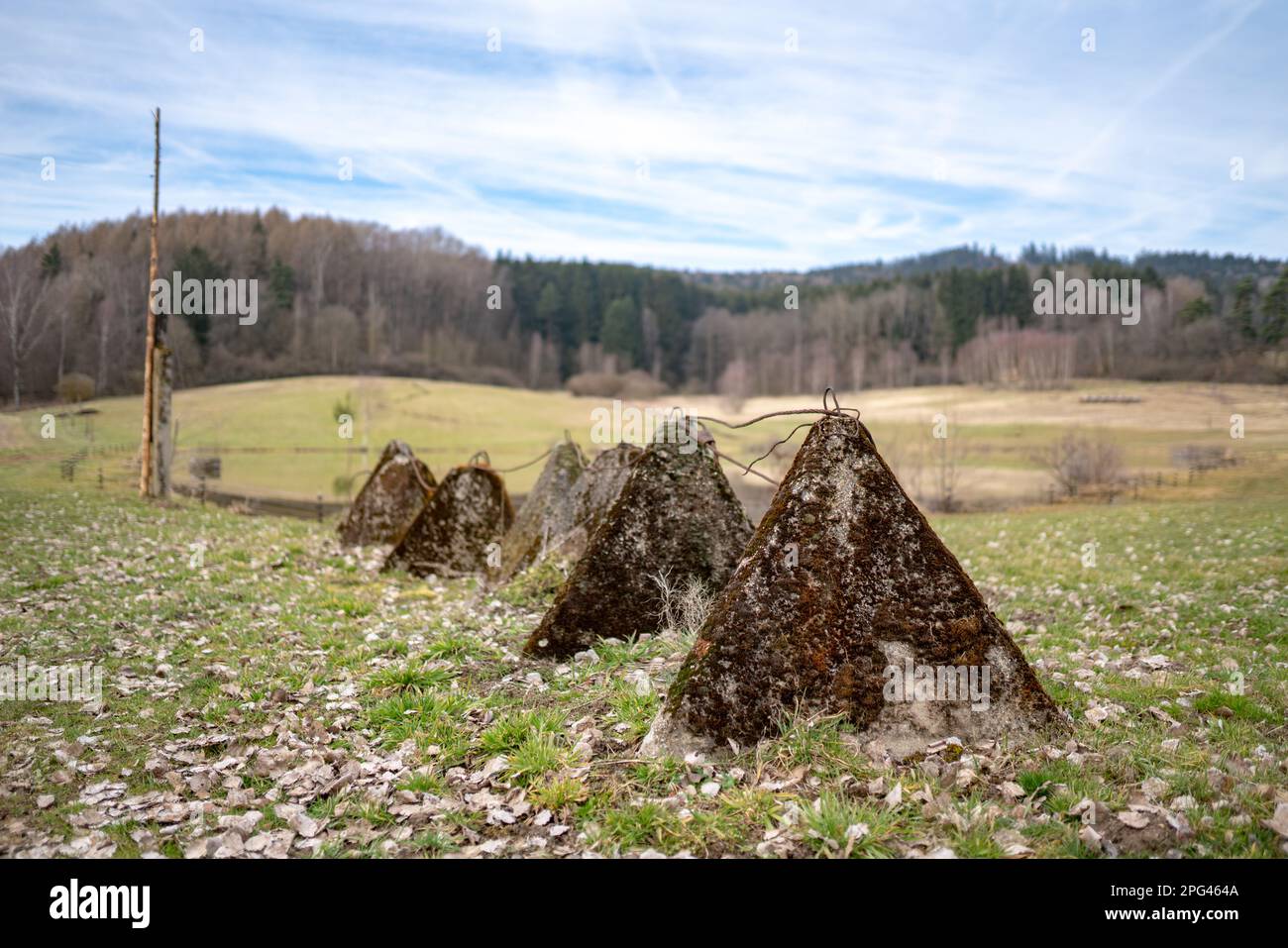 Vieux rideau de fer les dents de dragon de type obstacles en béton debout dans le paysage près de la frontière tchèque-allemande. Mise au point peu profonde avec arrière-plan flou. Banque D'Images