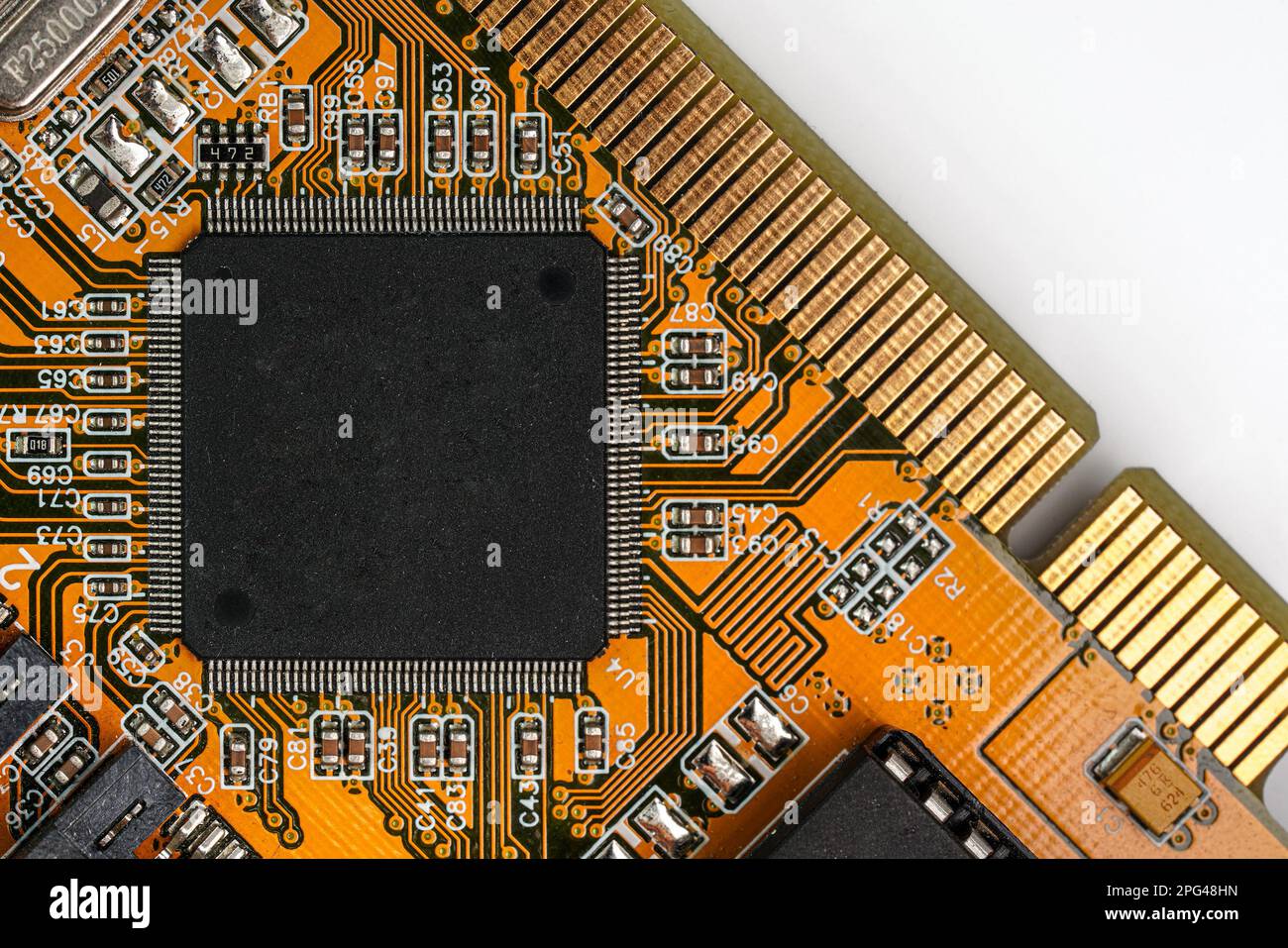 Carte de circuit imprimé orange avec puce noire - espace pour le texte - au milieu, vue du dessus Banque D'Images
