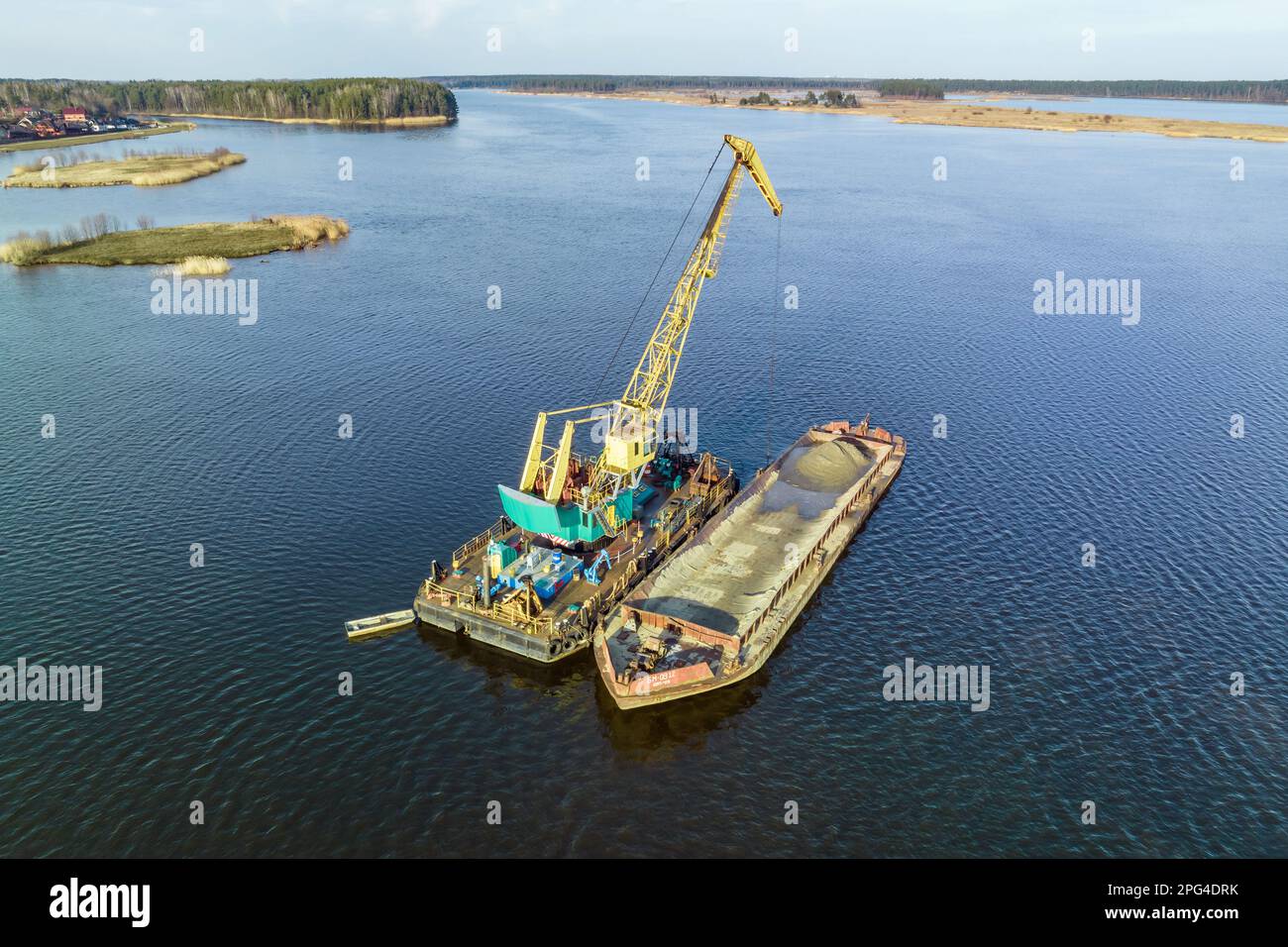 vue aérienne sur la grue extrait les minéraux du fond sur une immense barge au milieu du lac ou de la mer Banque D'Images
