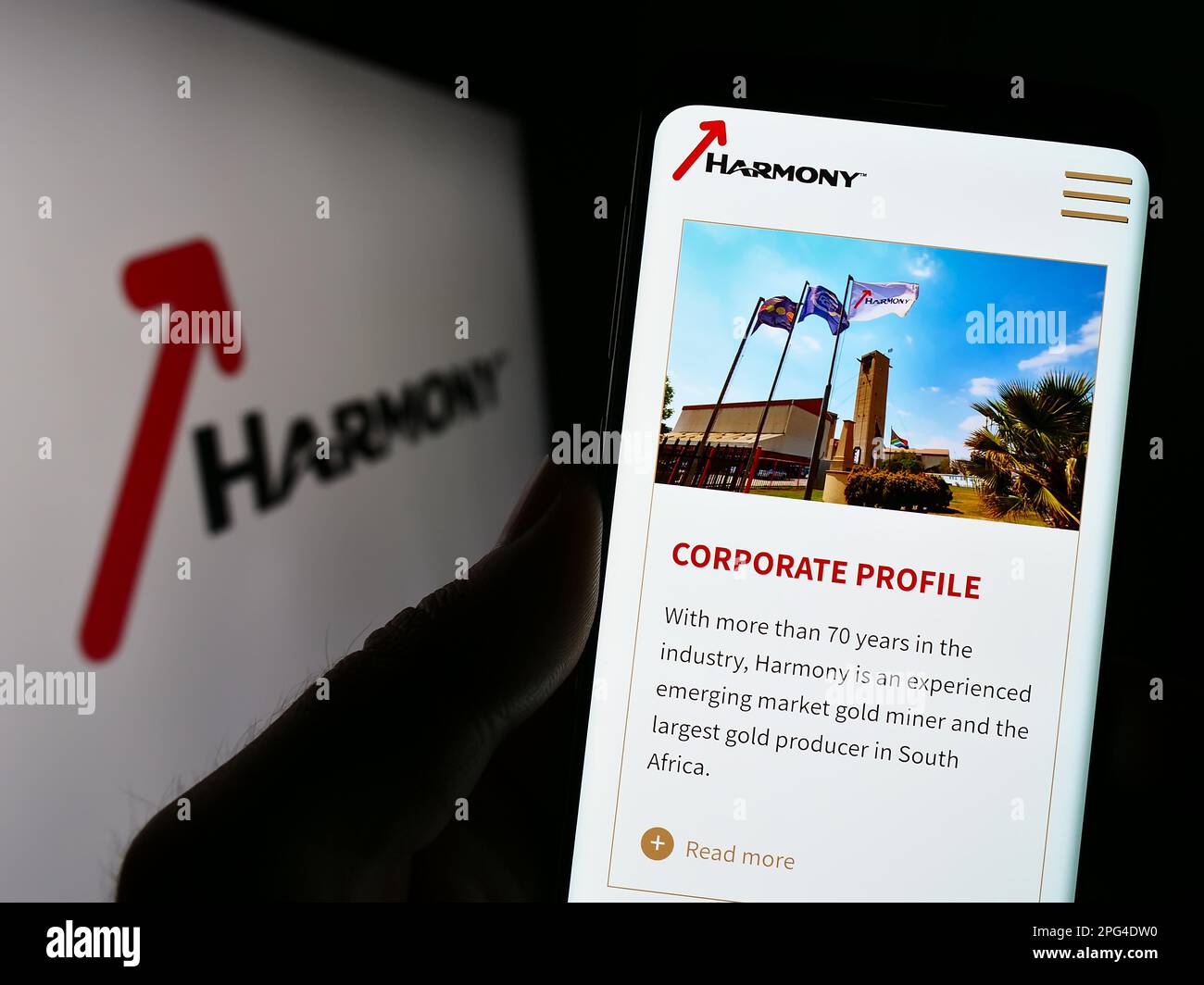 Personne tenant un téléphone cellulaire avec le site Web de la société Harmony Gold Mining Co. Ltd. Sur l'écran devant le logo. Concentrez-vous sur le centre de l'écran du téléphone. Banque D'Images