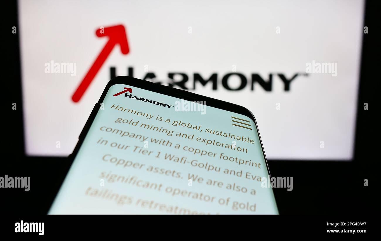 Smartphone avec la page Web de la société sud-africaine Harmony Gold Mining Co. Ltd. À l'écran devant le logo. Faites la mise au point dans le coin supérieur gauche de l'écran du téléphone. Banque D'Images