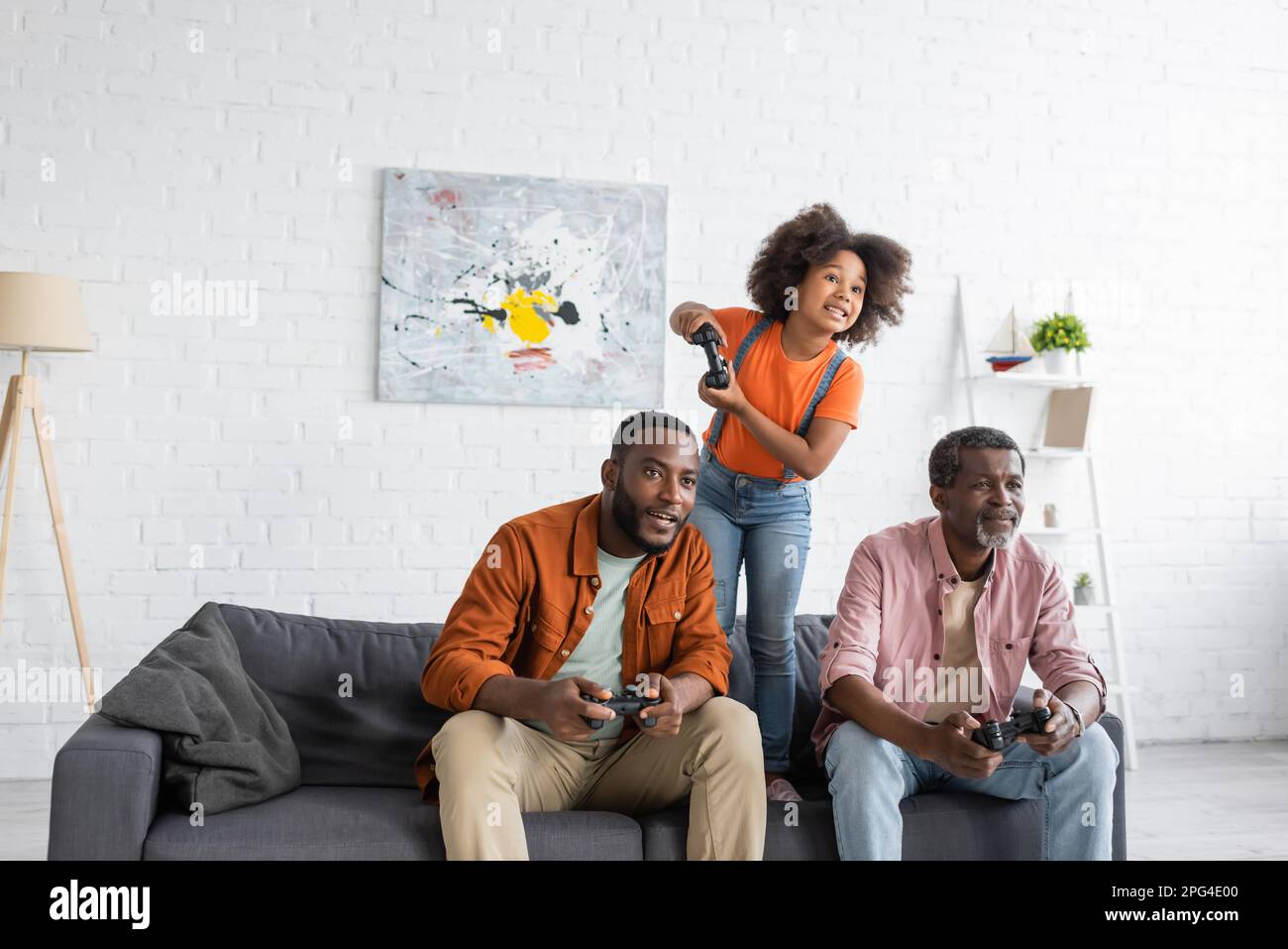 KIEV, UKRAINE - 17 JUILLET 2021: Famille afro-américaine positive avec fille jouant au jeu vidéo à la maison Banque D'Images