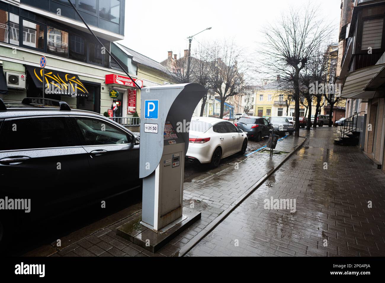 Ivano-Frankivsk, Ukraine - Mars, 2023: Machine de stationnement dans la rue de la ville pluvieuse. Banque D'Images