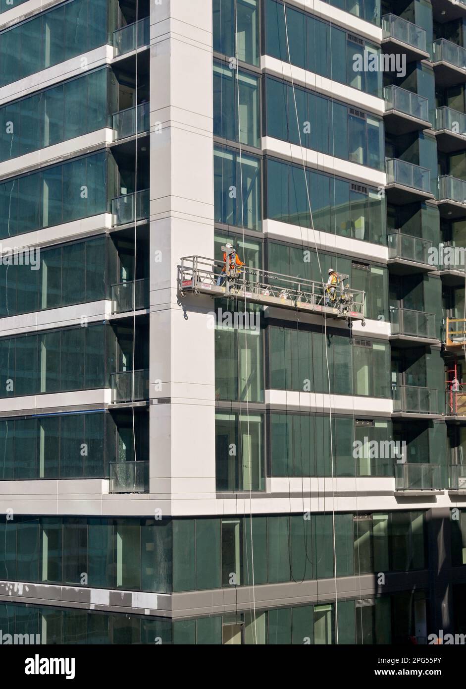 Austin, Texas, États-Unis - février 2023 : nettoyeurs de fenêtres sur un berceau suspendu à l'extérieur d'un immeuble de bureaux dans le centre-ville Banque D'Images