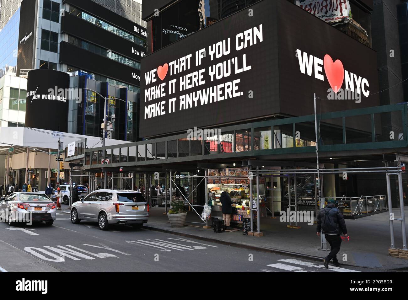 Les gens marchent à proximité des panneaux d'affichage numériques affichant « We Love NYC » lors du lancement de la campagne « We Love NYC » à Times Square sur 20 mars 2023 en N Banque D'Images