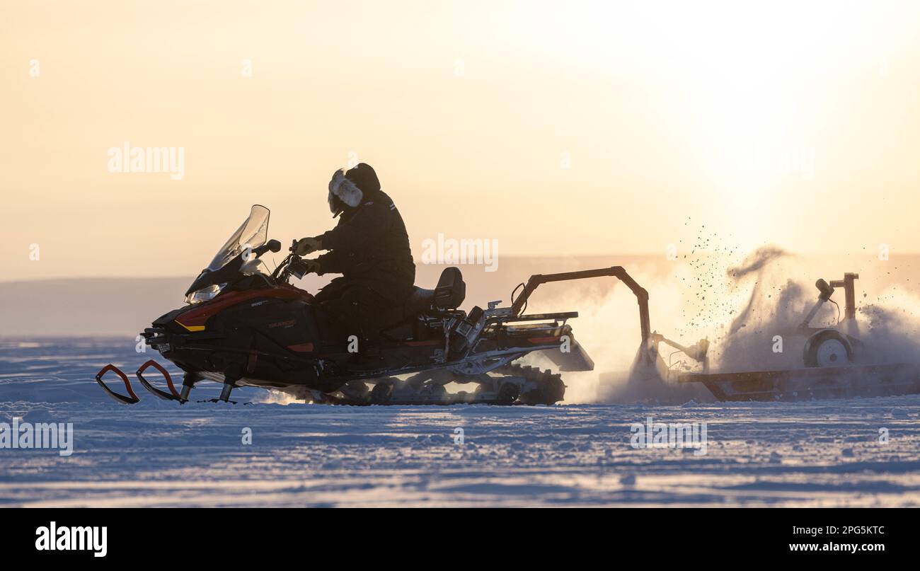 Un membre de l’équipe de ski du camp polaire de l’escadre 109th du transport aérien, le Lt Col Kevin Jones, conduit une machine à neige pour faire fonctionner une piste à Templeton Bay, Nunavut, Canada 13 mars 2023. Le chemin de ski a permis au LC-130s du 109ths de transporter du personnel et du fret dans l’environnement arctique austère lors de l’exercice Guerrier Nordique 2023. (É.-U. Photo de la Garde nationale aérienne par le sergent d'état-major Madison Scaringe) Banque D'Images