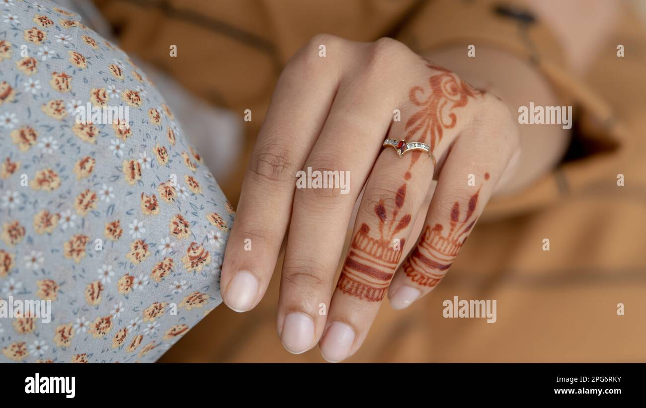 Femme musulmane avec tatouage au henné sur ses mains à l'extérieur, sourire face avec hijab gros plan Banque D'Images