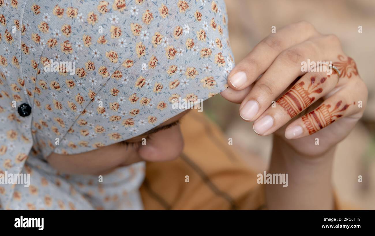 Femme musulmane avec tatouage au henné sur ses mains, sourire face avec hijab gros plan Banque D'Images
