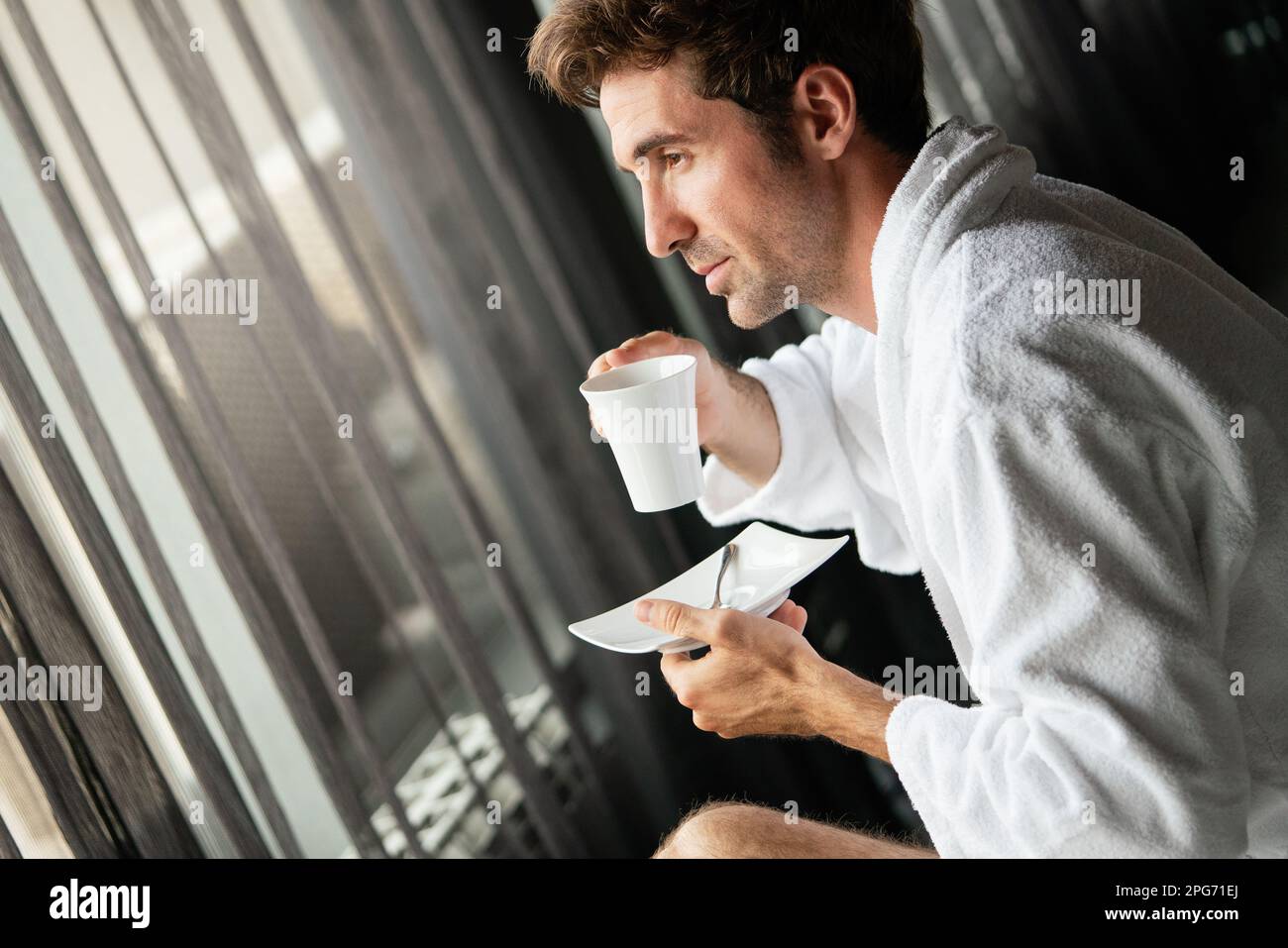 Un jeune homme boit du café le matin à l'hôtel, au spa Banque D'Images