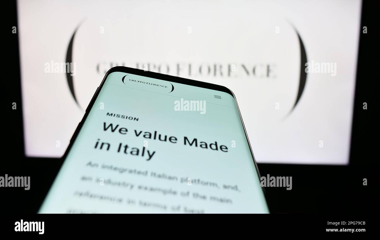 Smartphone avec le site Internet de la société italienne de mode Gruppo Florence spa à l'écran devant le logo de l'entreprise. Faites la mise au point dans le coin supérieur gauche de l'écran du téléphone. Banque D'Images