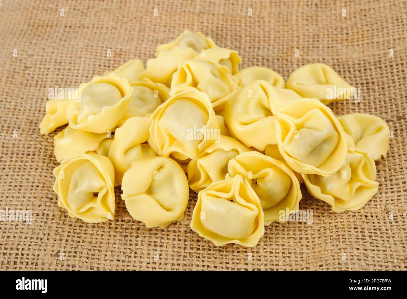 Pile de pâtes tortellini sur fond de jute Banque D'Images