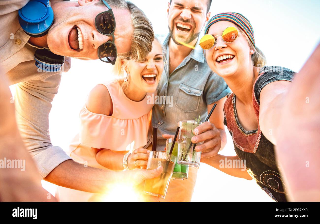 Groupe de gens branchés prenant le selfie au festival de vacances de printemps toaster des cocktails fantaisie au coucher du soleil - joie d'été et amitié concept avec de jeunes amis Banque D'Images